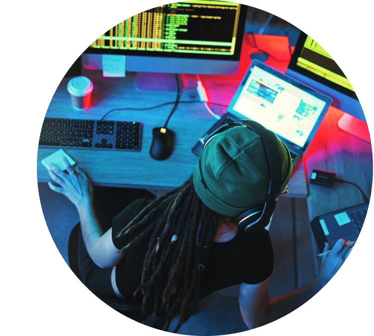 Woman in hat sitting at desk with laptop